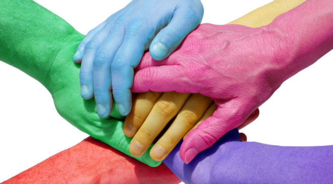 Five hands painted in different colors in a hand huddle intended to symbolize inclusion for all.